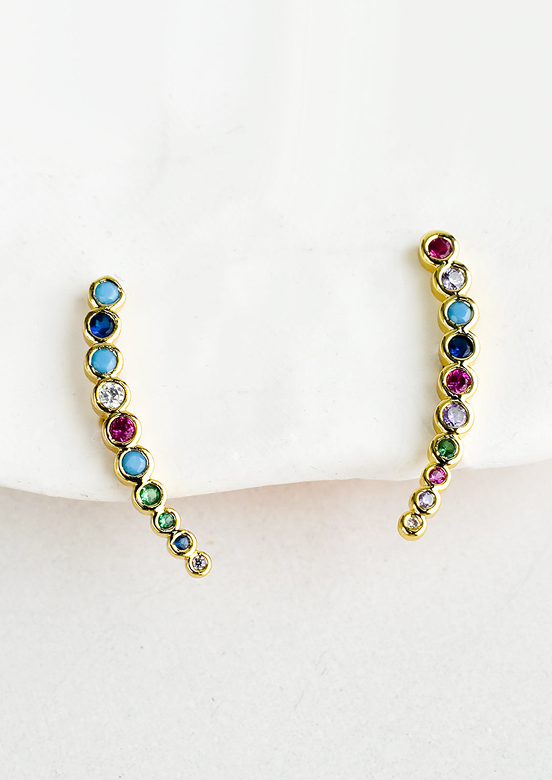 A pair of tapered climber earrings with multicolor bezel set crystals.