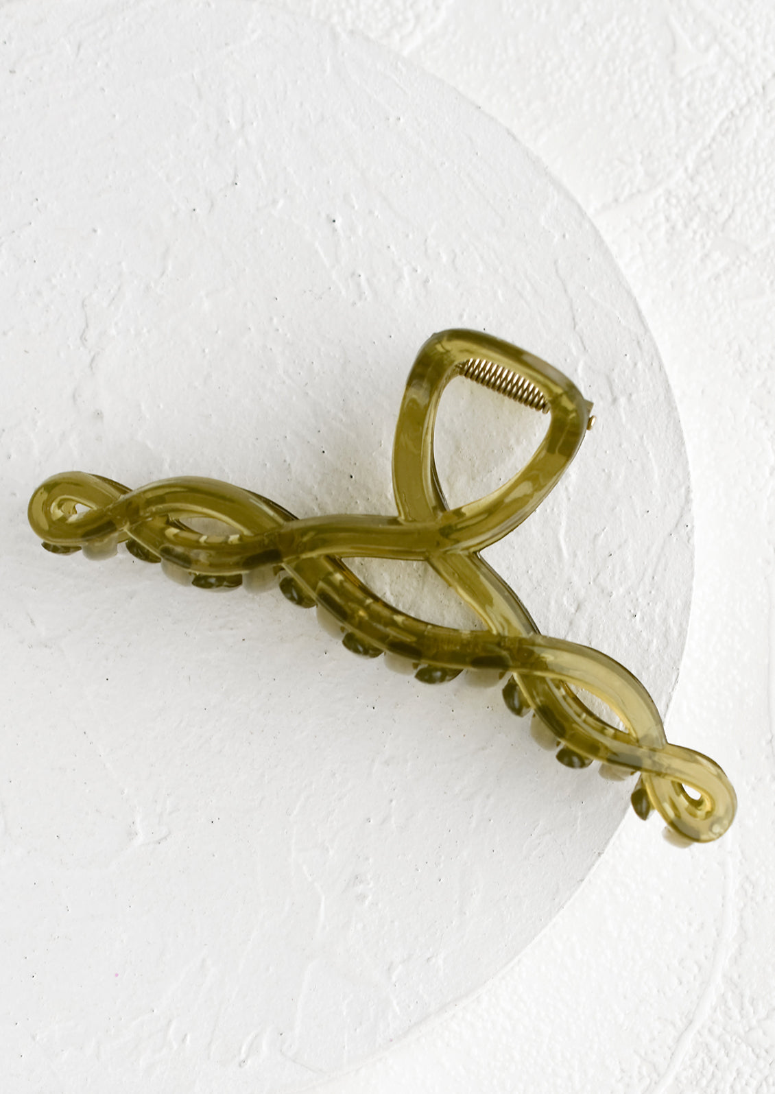 A spiral shaped hair claw in olive green.