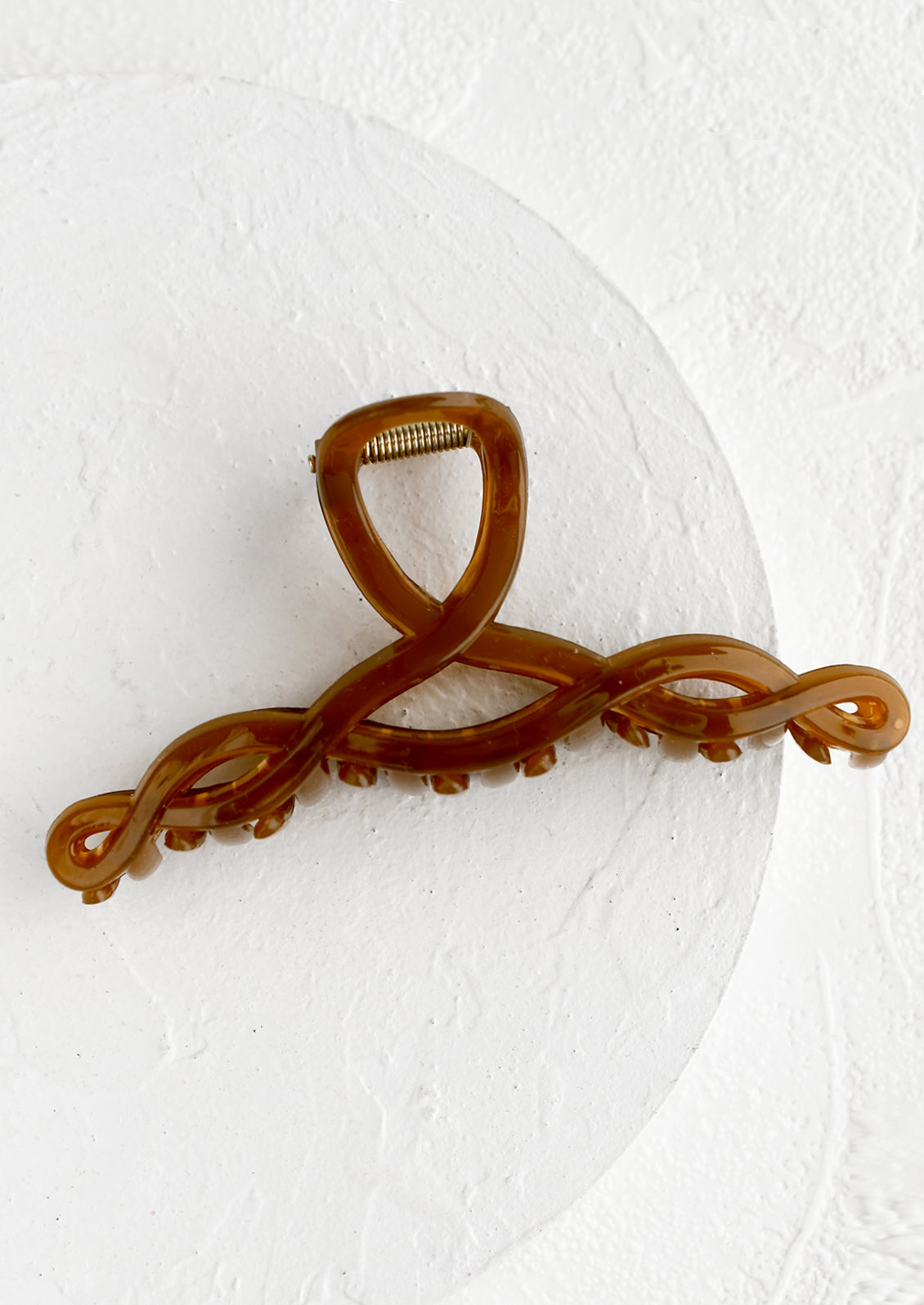 A spiral shaped hair claw in brown sugar.