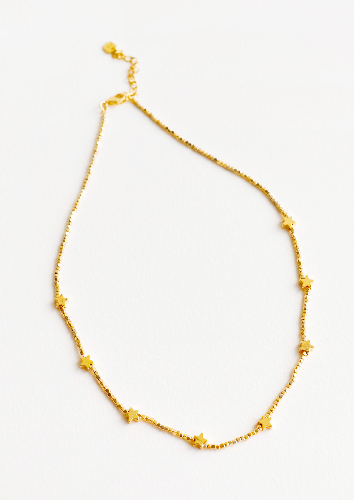 Short necklace featuring round yellow gold beads interspersed with gold star beads and an adjustable closure.