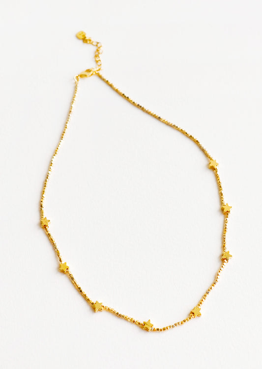 Short necklace featuring round yellow gold beads interspersed with gold star beads and an adjustable closure.