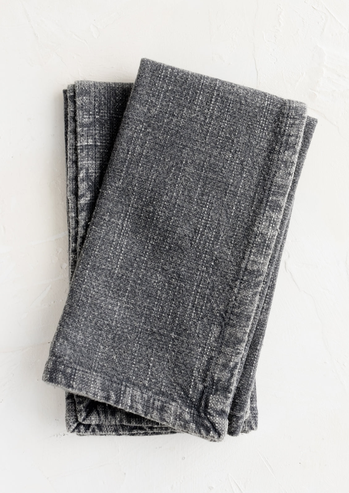 A pair of stonewashed napkins in mineral grey.