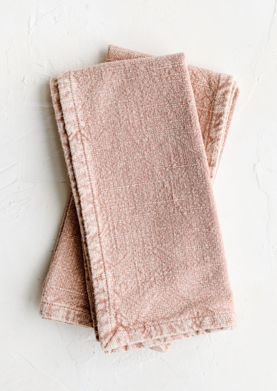 A pair of stonewashed napkins in rose pink.