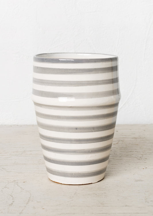 A moroccan style ceramic cup in grey and white stripes.