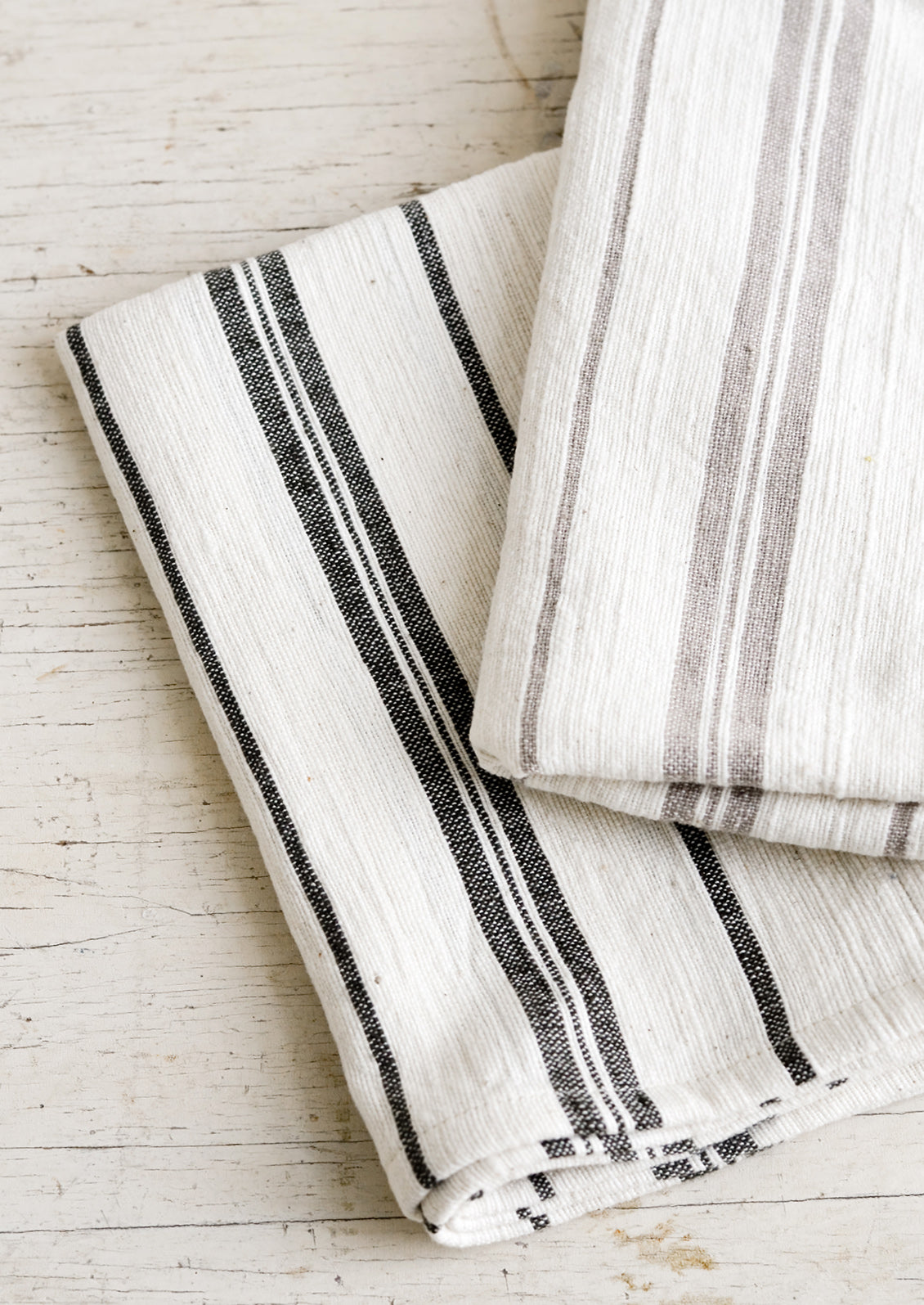 Two striped cotton hand towels in black and taupe colorways.