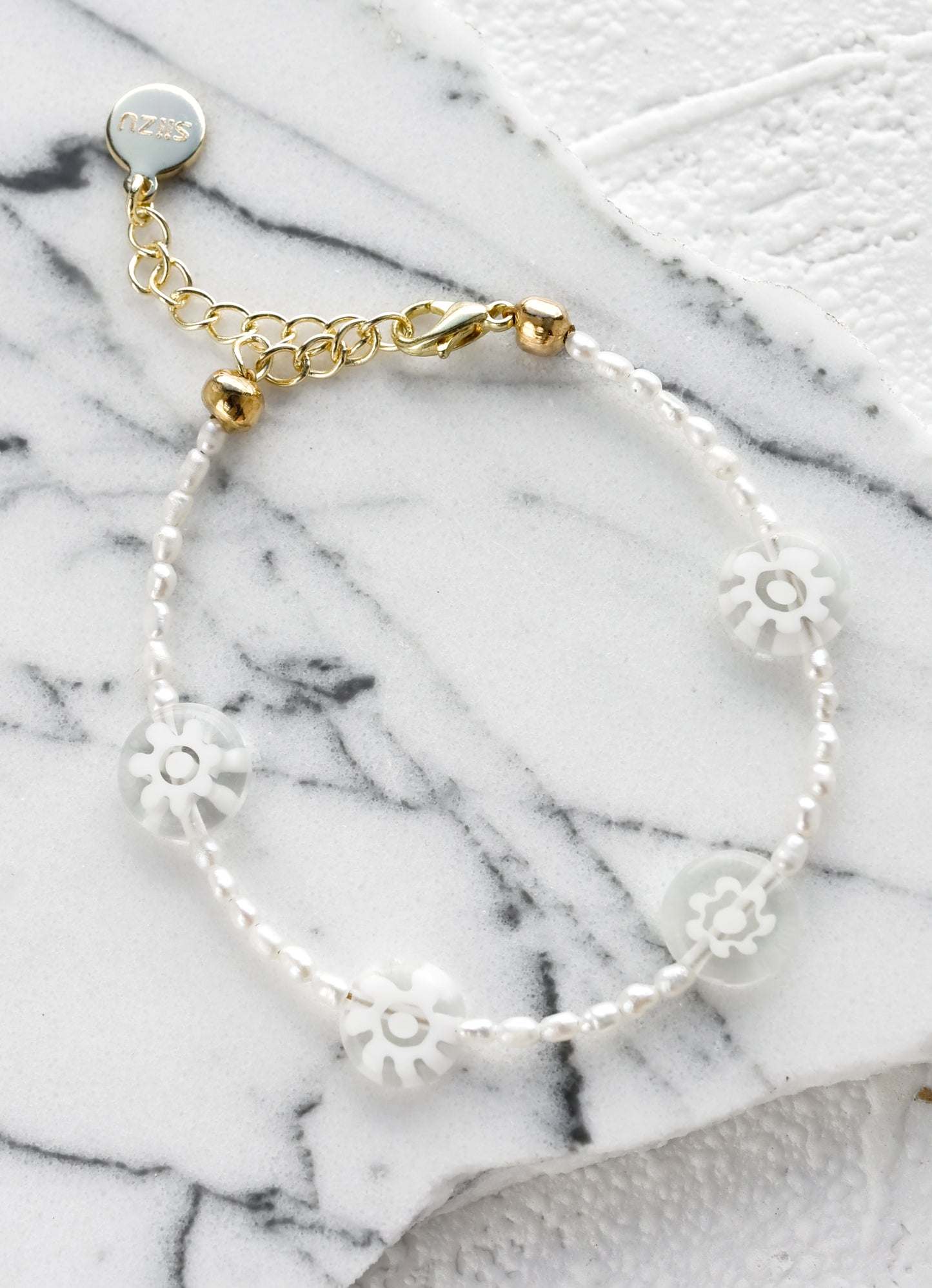 A pearl beaded bracelet with clear millefiore glass daisy beads.