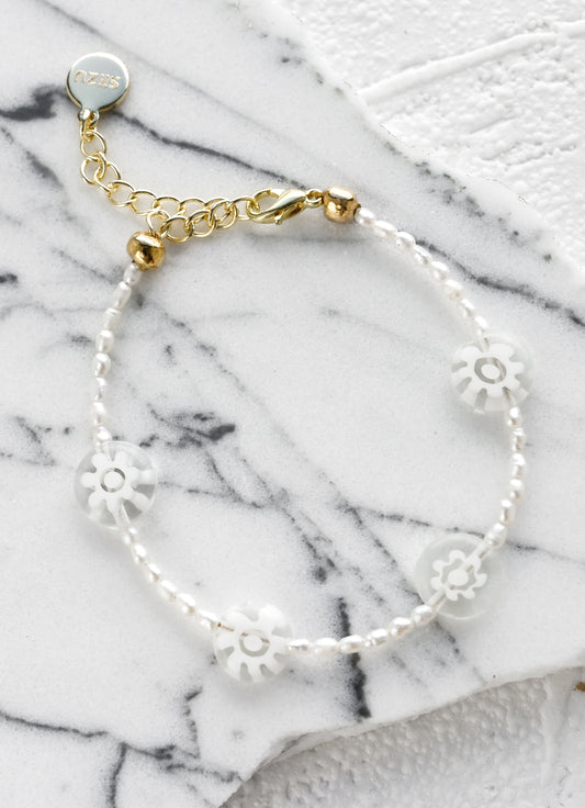 A pearl beaded bracelet with clear millefiore glass daisy beads.
