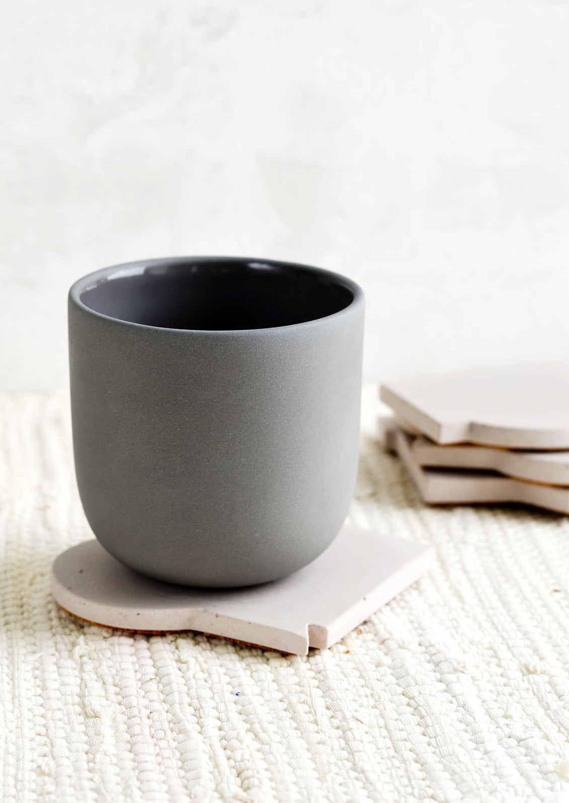 A ceramic cup on top of a coaster.