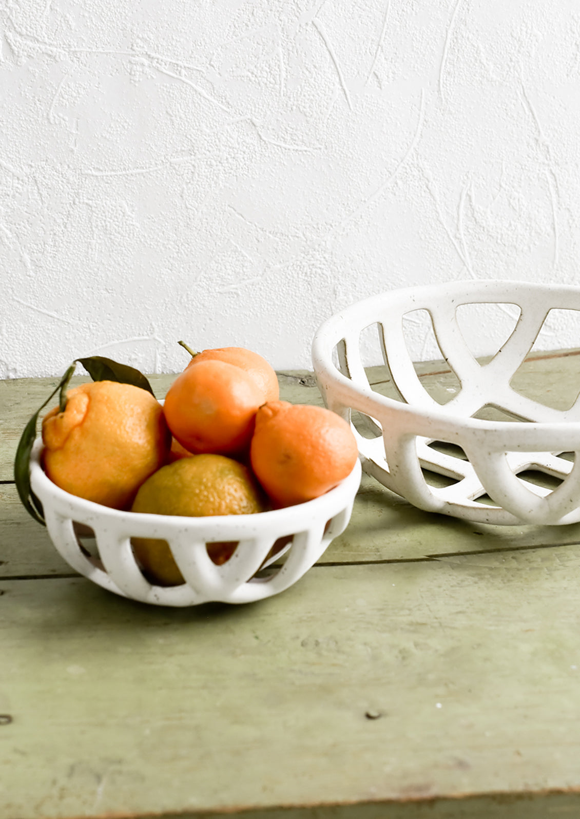 White ceramic fruit bowls in small and large sizes.