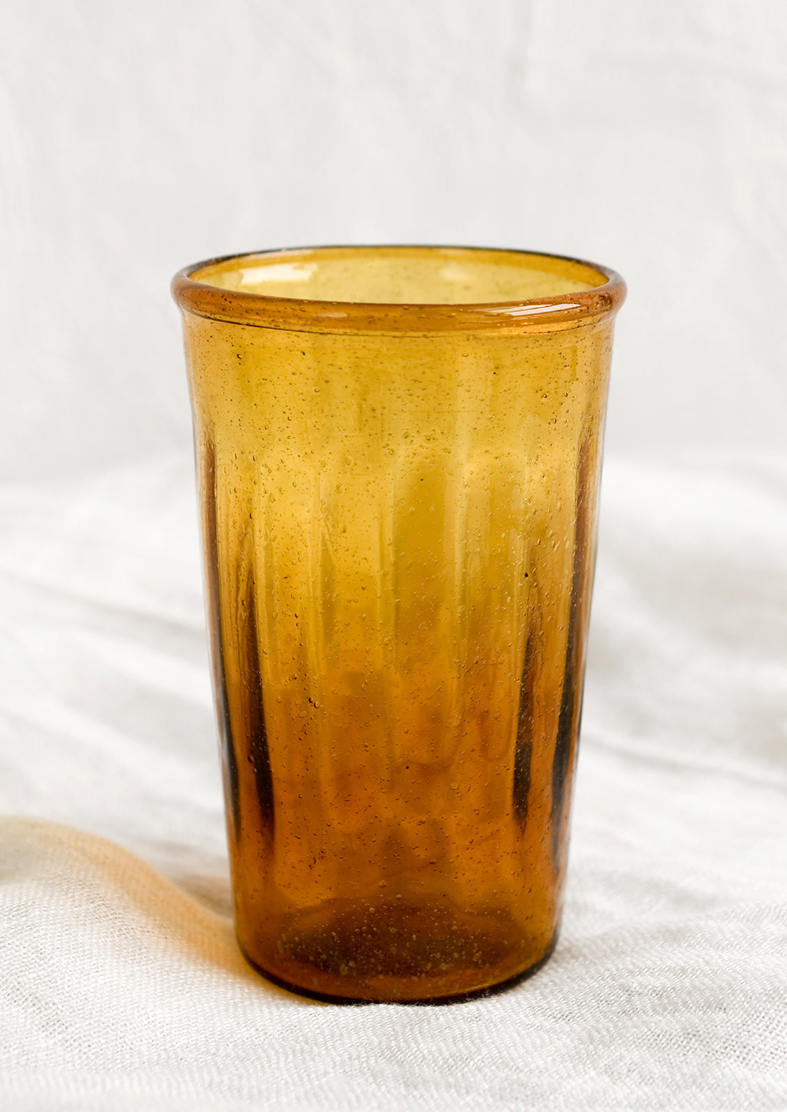 A glass tumbler in amber color.