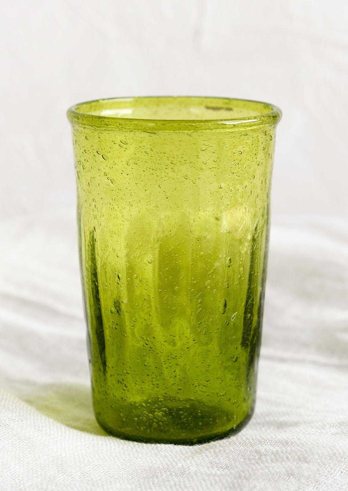 A glass tumbler in lime green color.