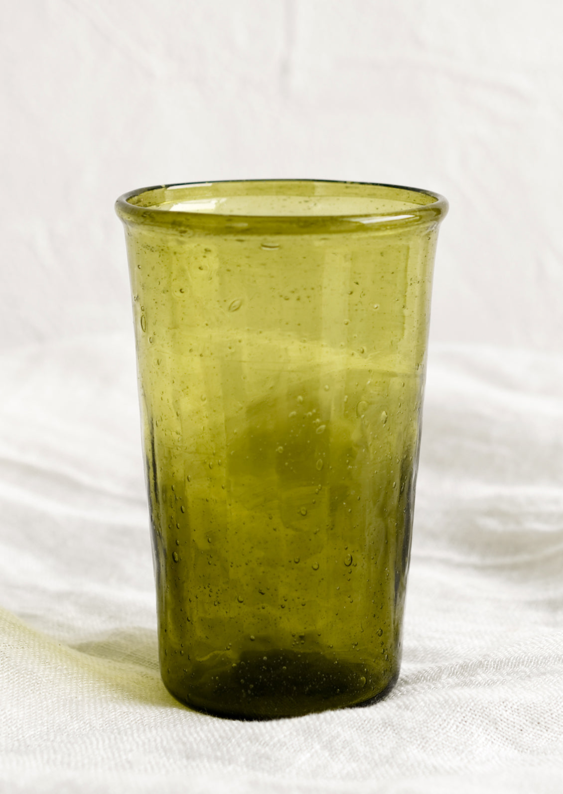 A glass tumbler in olive green color.