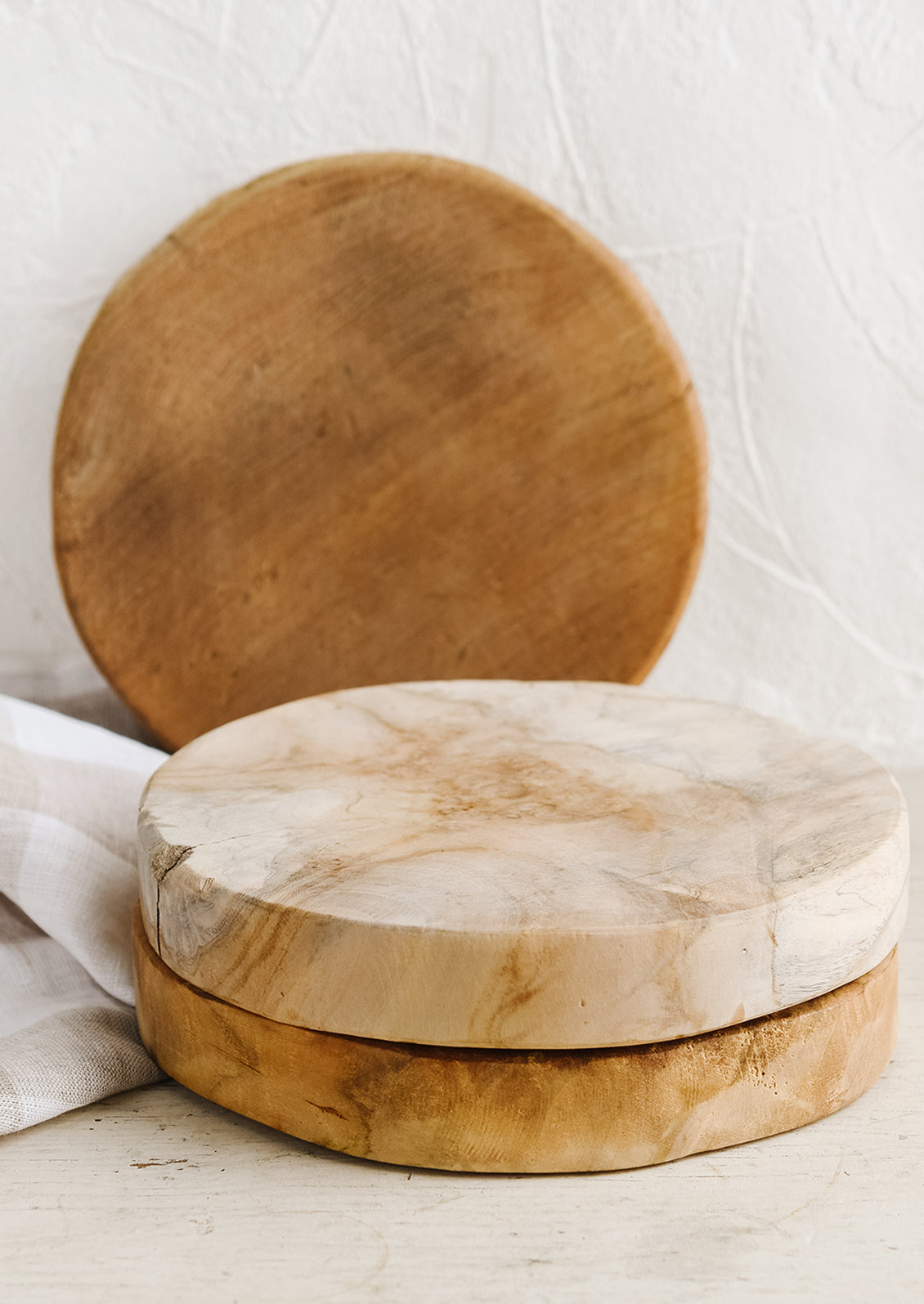 A round pedestal board made from natural teak.