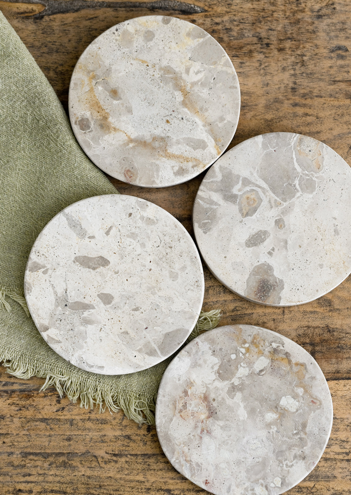A set of round, beige marble coasters.