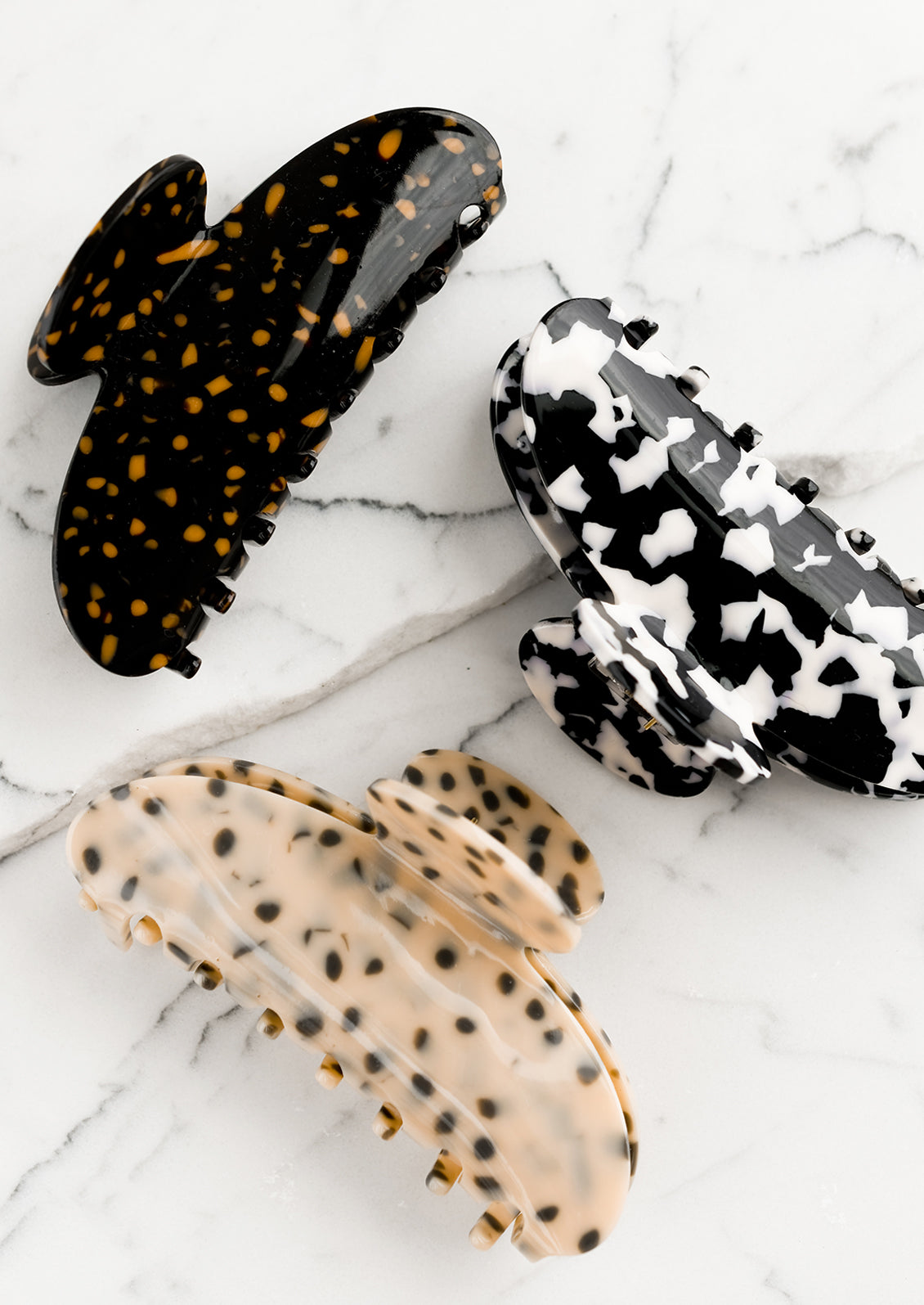 Terrazzo patterned hair claws in assorted colors.