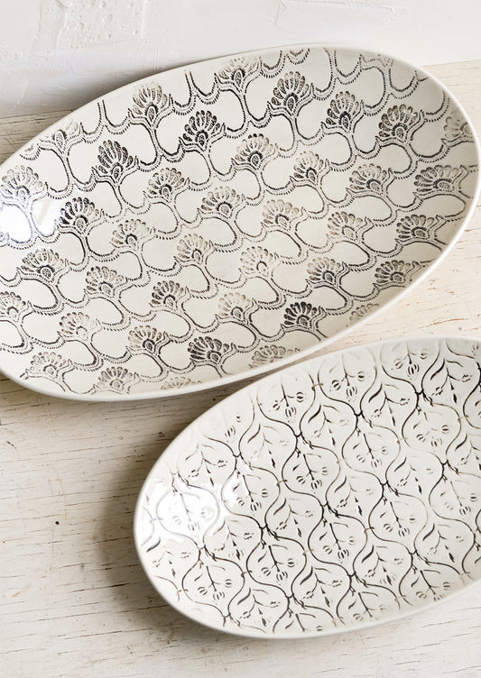 Oval shaped ceramic platters with black and white textile pattern.