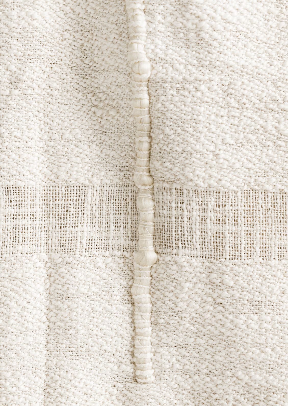 A natural cotton throw with paneling detailing.
