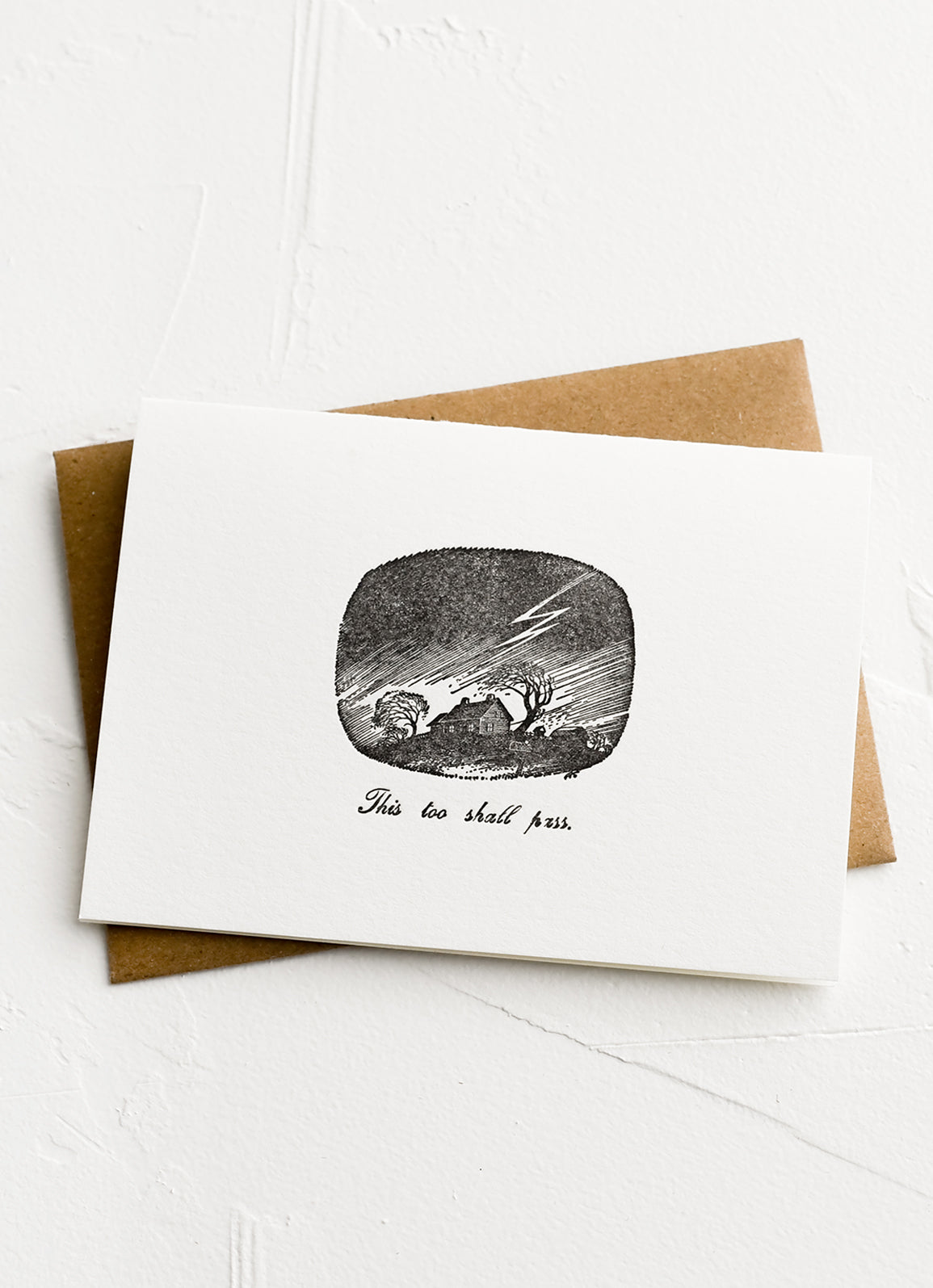 A greeting card with image of a storm and text below reading "This too shall pass".