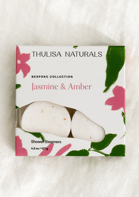 A box of shower steamer tablets in jasmine & amber scent.