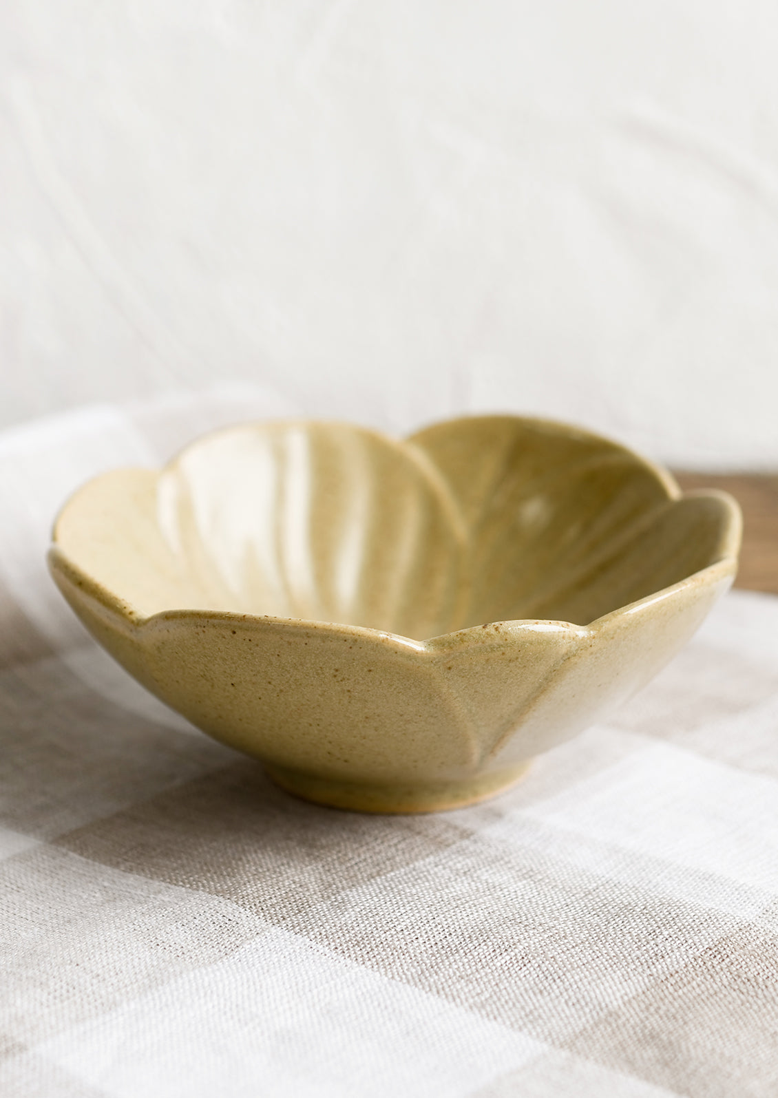 A tan ceramic flower shaped bowl.