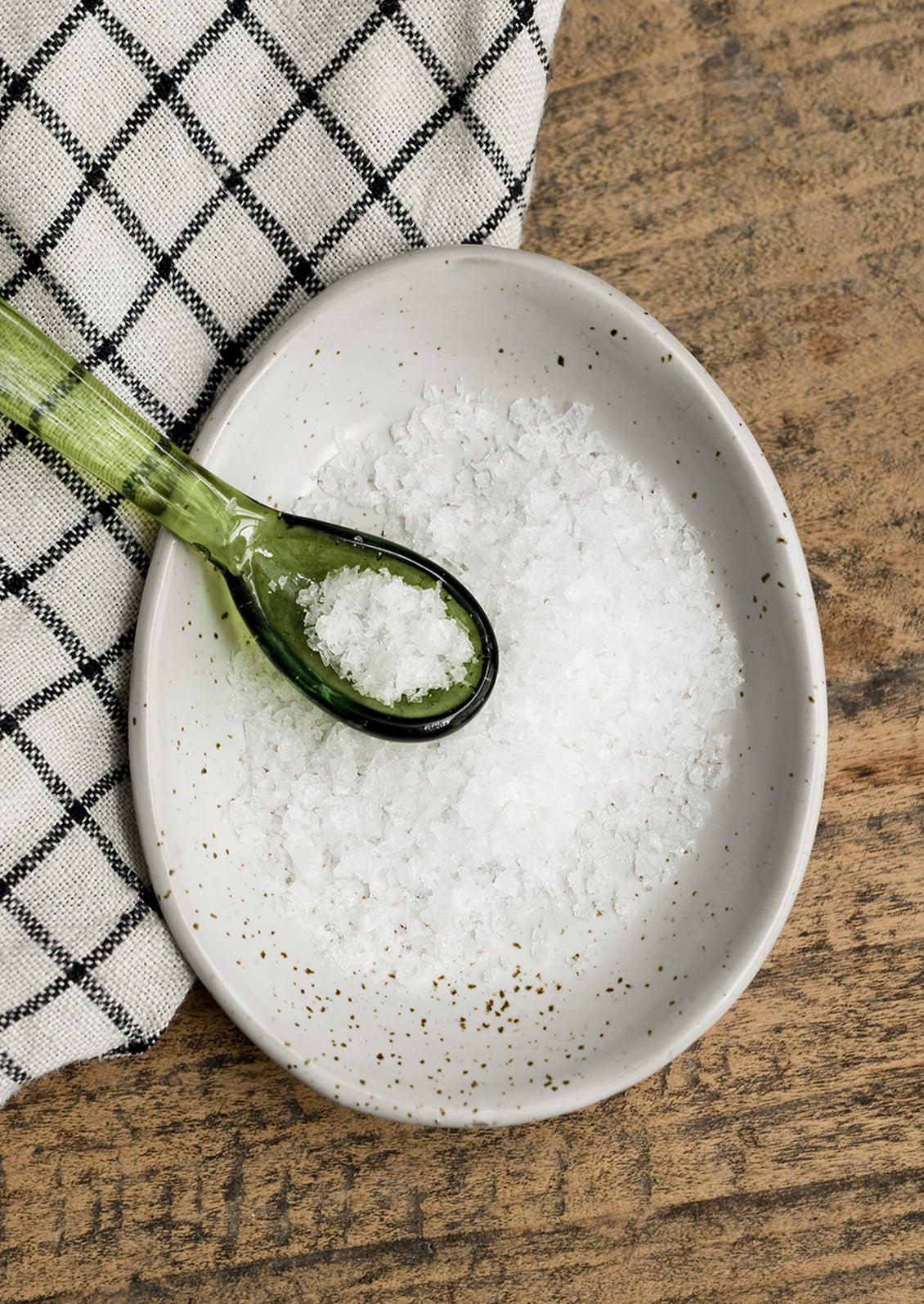 An egg shaped ceramic trinket dish with salt and spoon.
