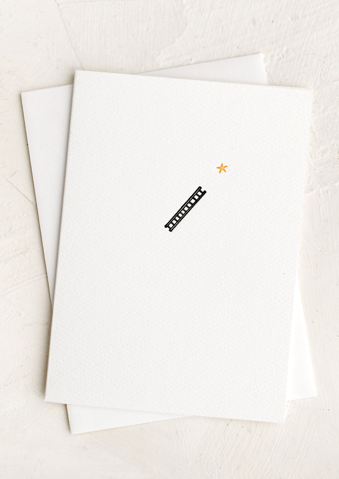 A plain white card with small ladder with star icon at front.