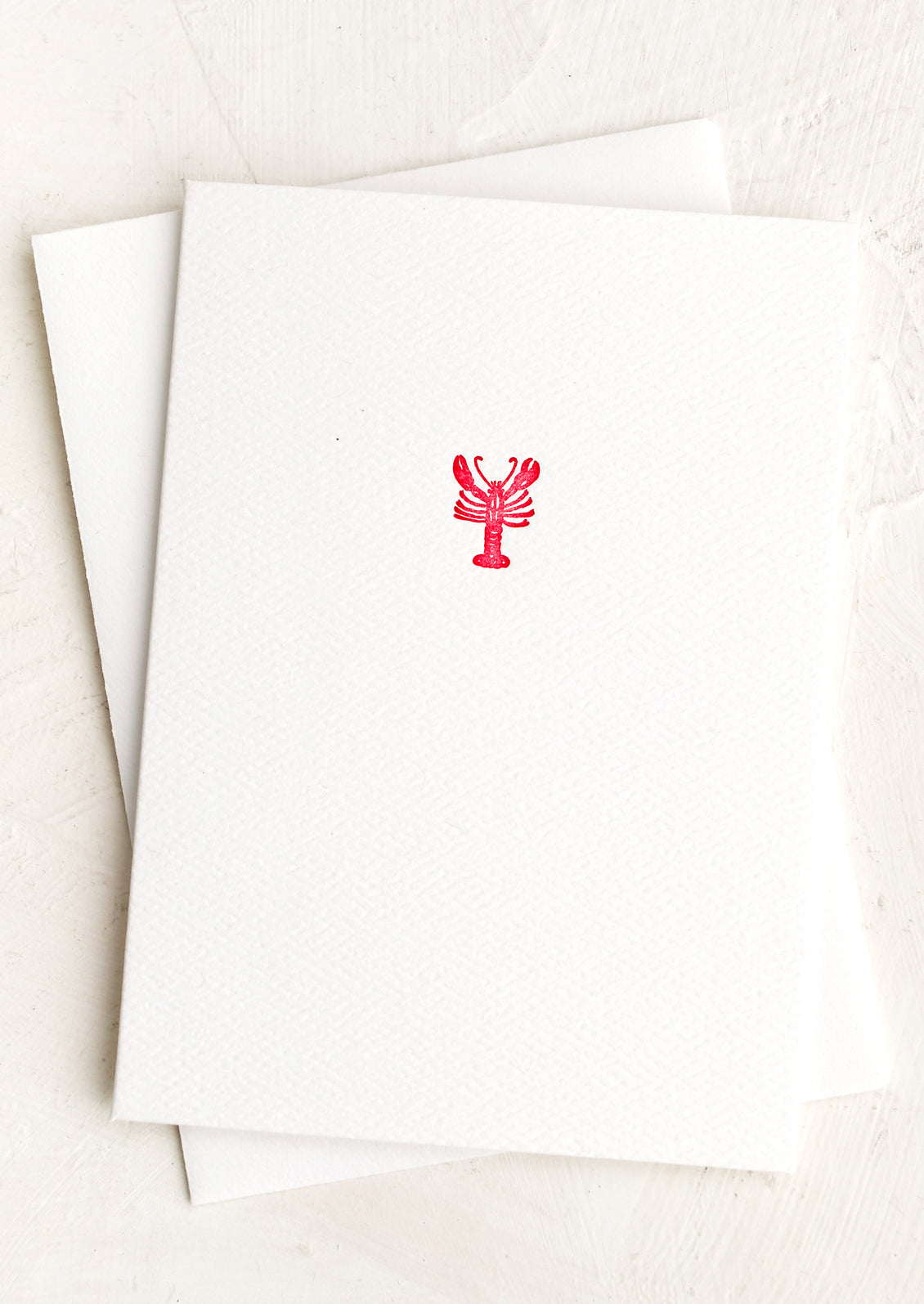 A plain white card with small red lobster at front.