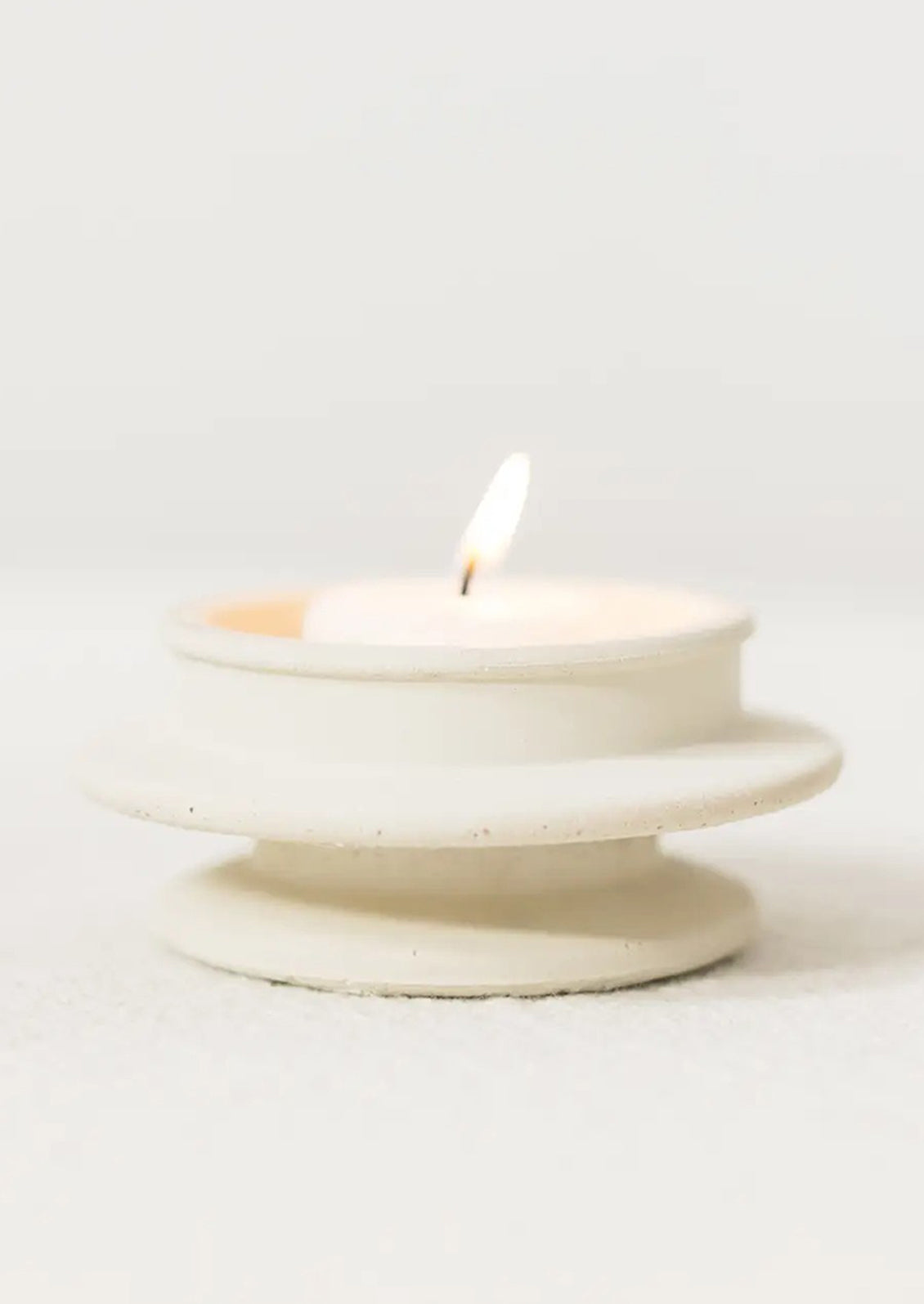 An architecturally shaped tealight holder in white.