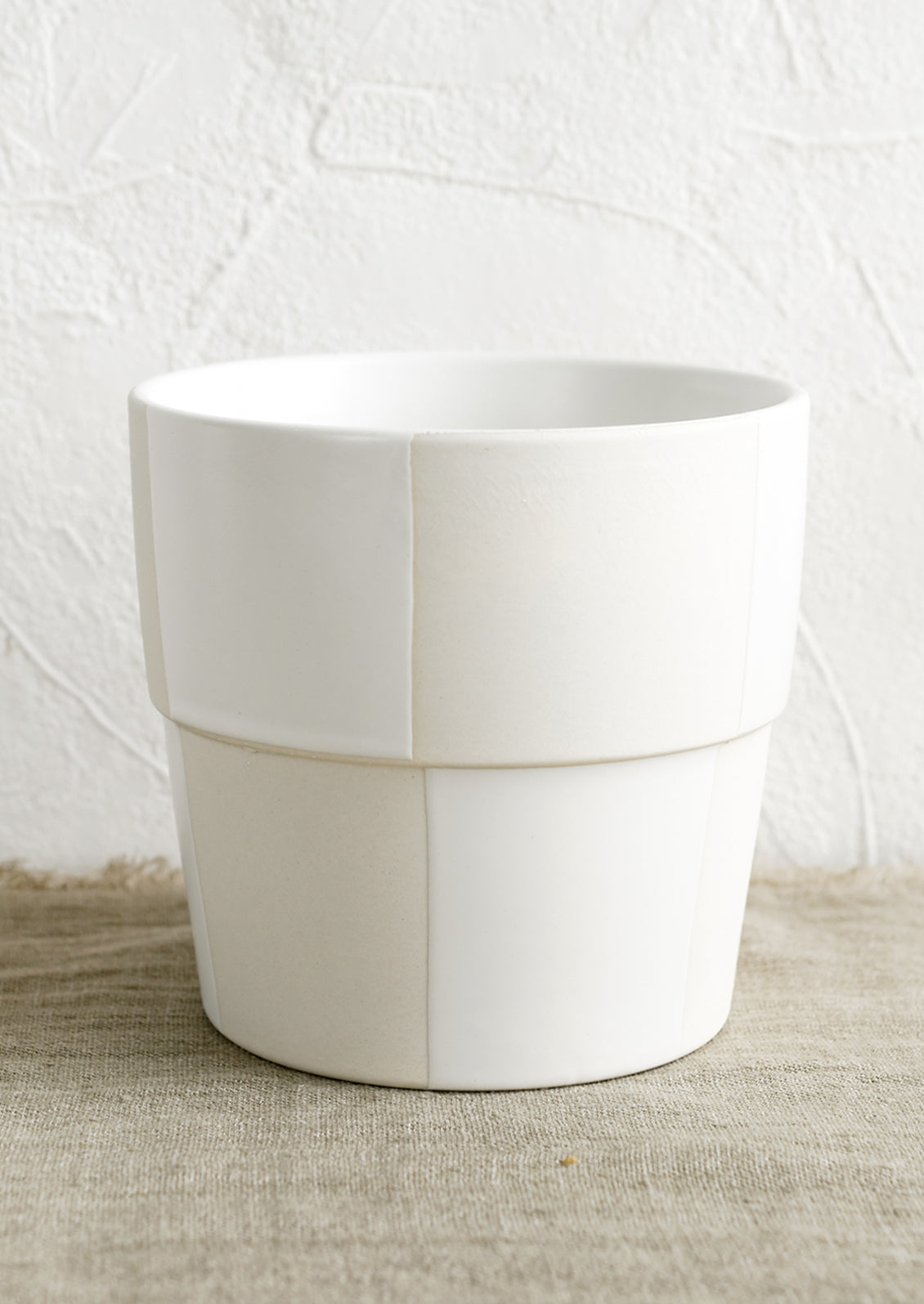 A large cream and white checker patterned planter pot.