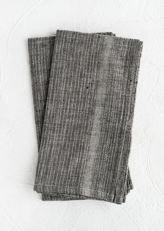 A pair of charcoal fabric napkins with textured tonal stripe pattern.