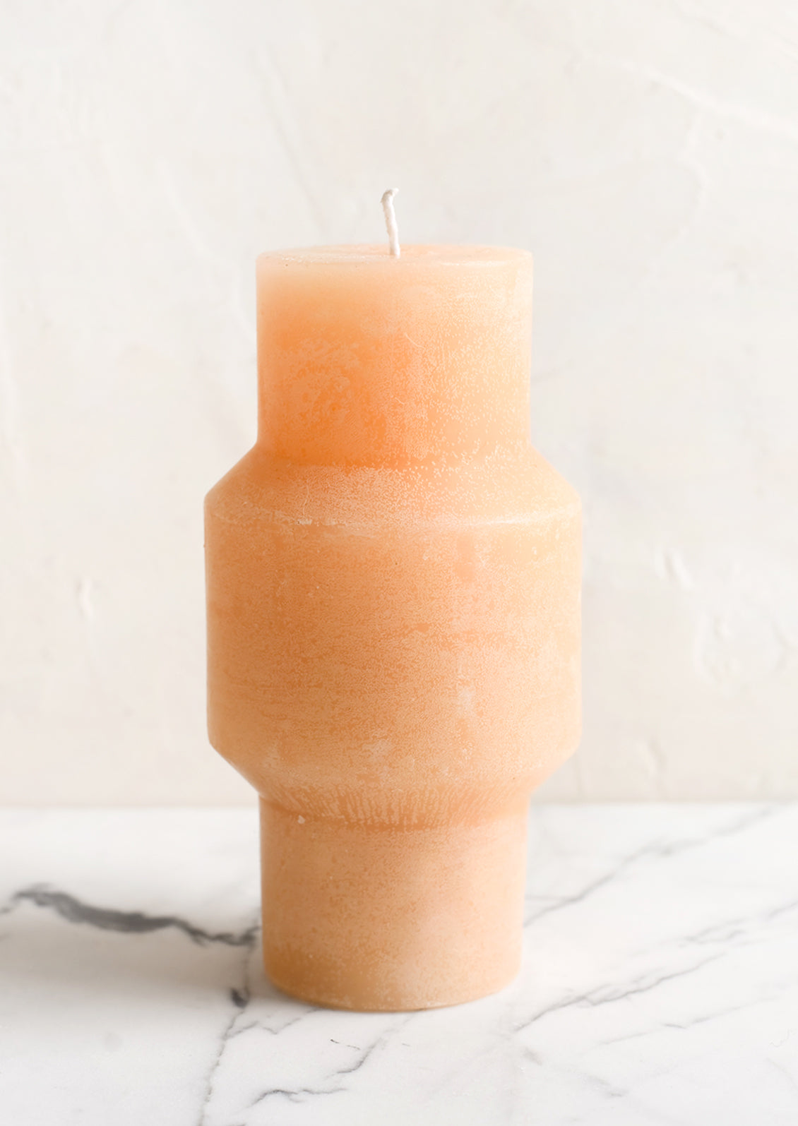A medium carved pillar candle with waxy finish in pomelo.