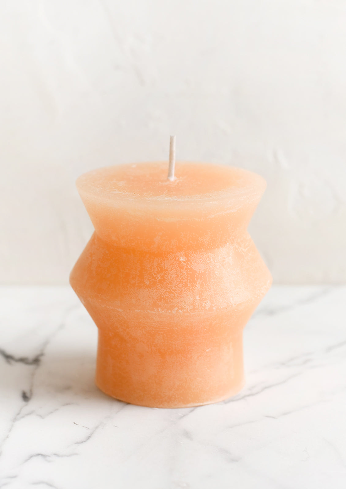 A small geometric pillar candle in pomelo.