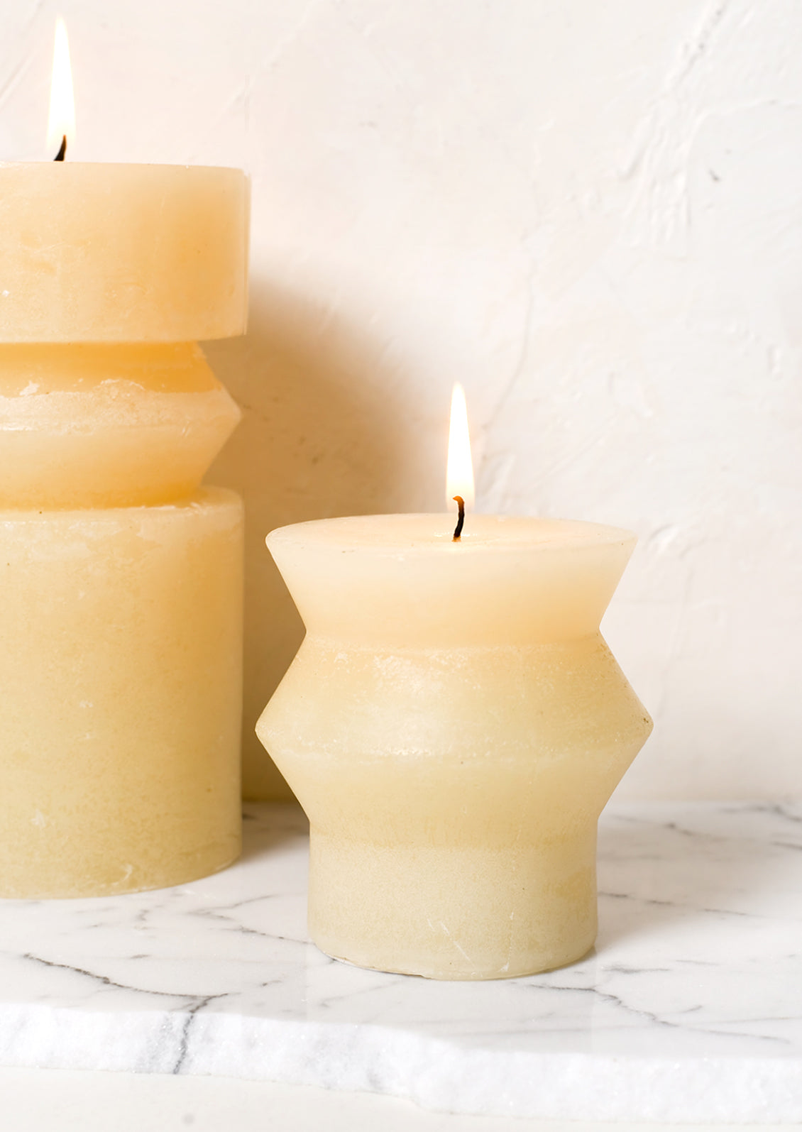 Vanilla colored pillar candles in assorted sizes.