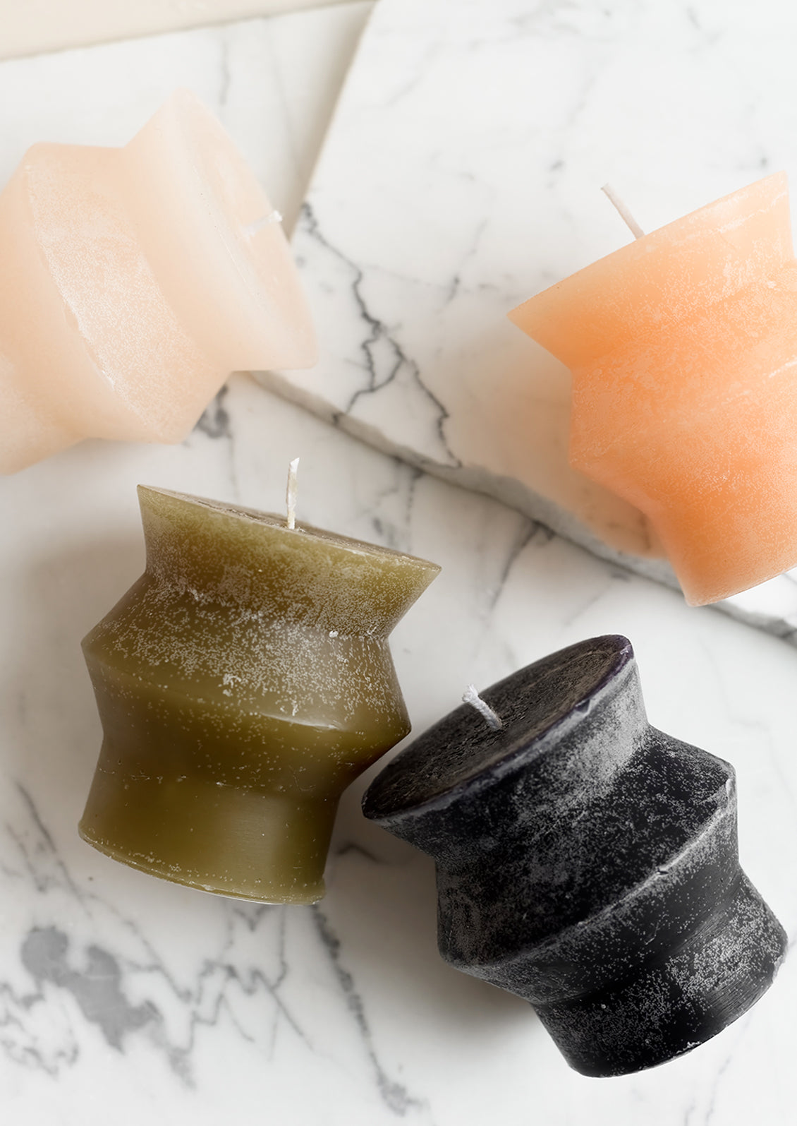 Assorted colors of small geometric shaped pillar candles.