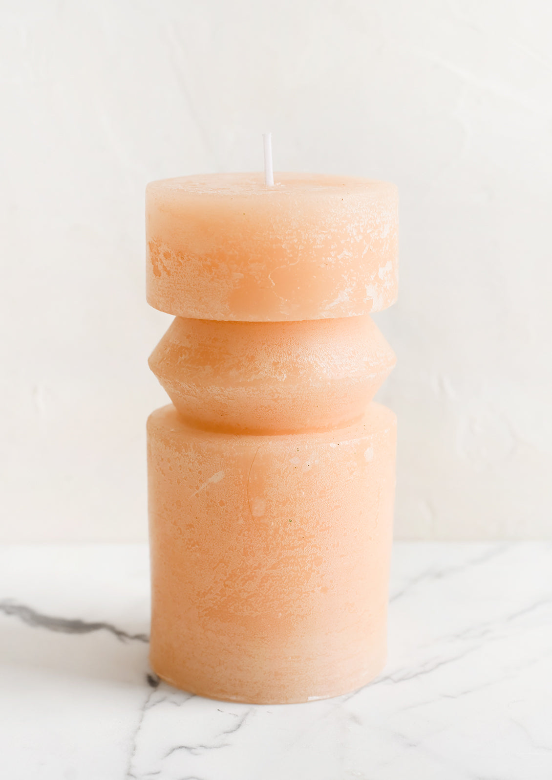 A medium carved pillar candle with waxy finish in pomelo.
