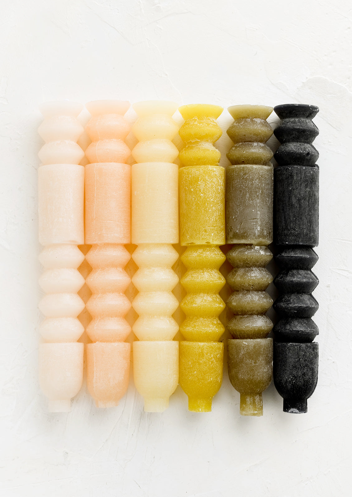 Carved geometric taper candles in assorted colors.