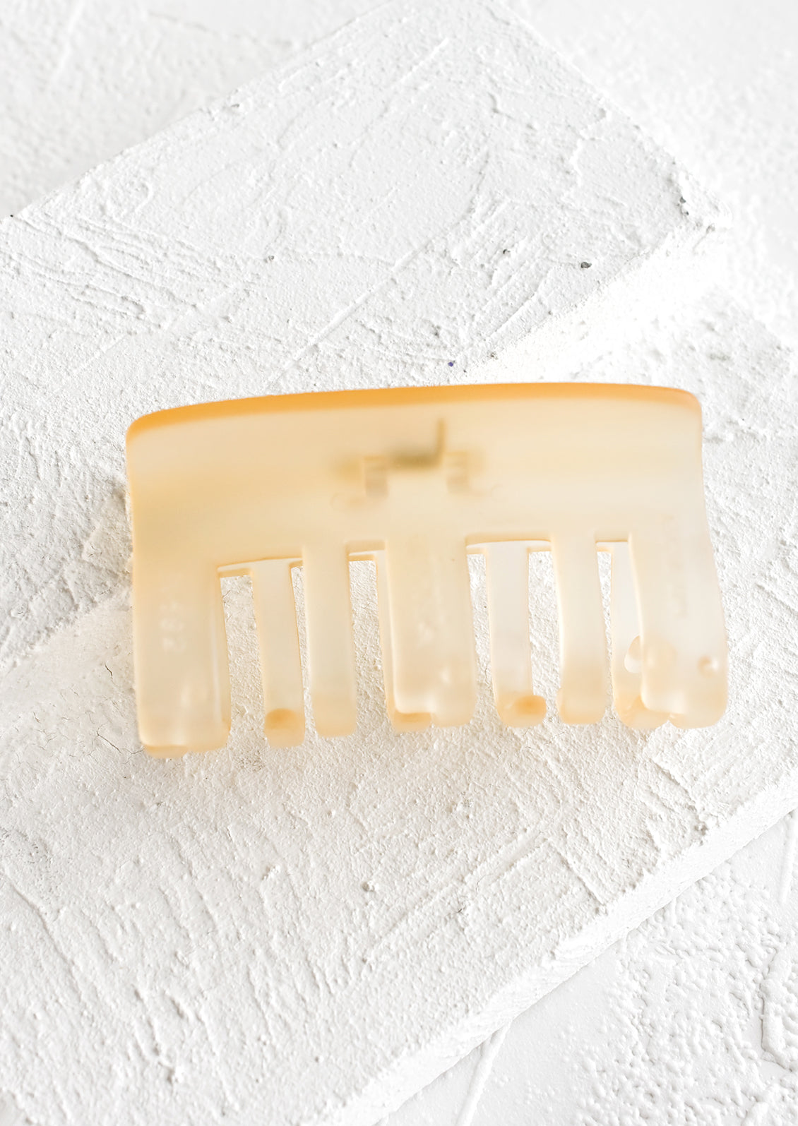 A matte translucent hair clip in pale honey.