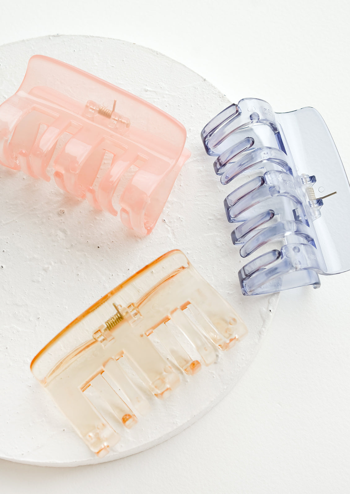 Three transparent hair claws in an assortment of colors.