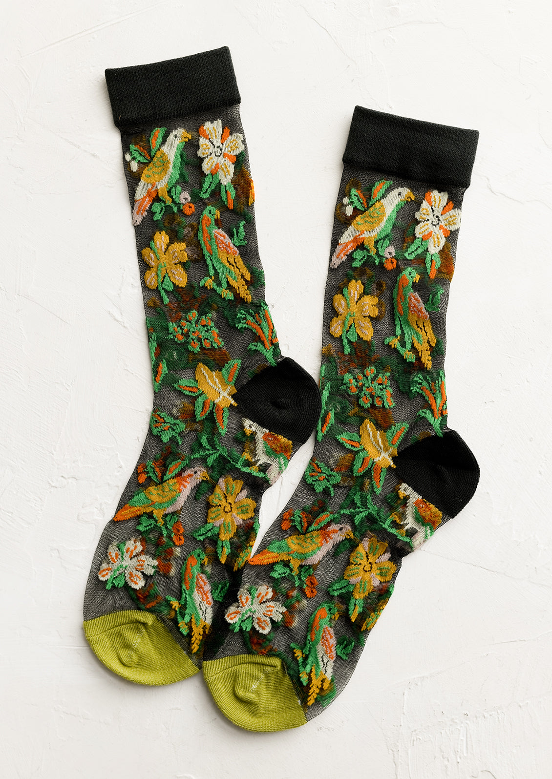 A pair of sheer black socks with tropical parrot print.