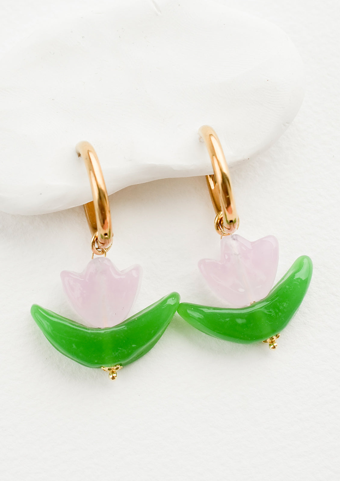 Glass earrings in the shape of a tulip in pink, with gold huggie hoop base.