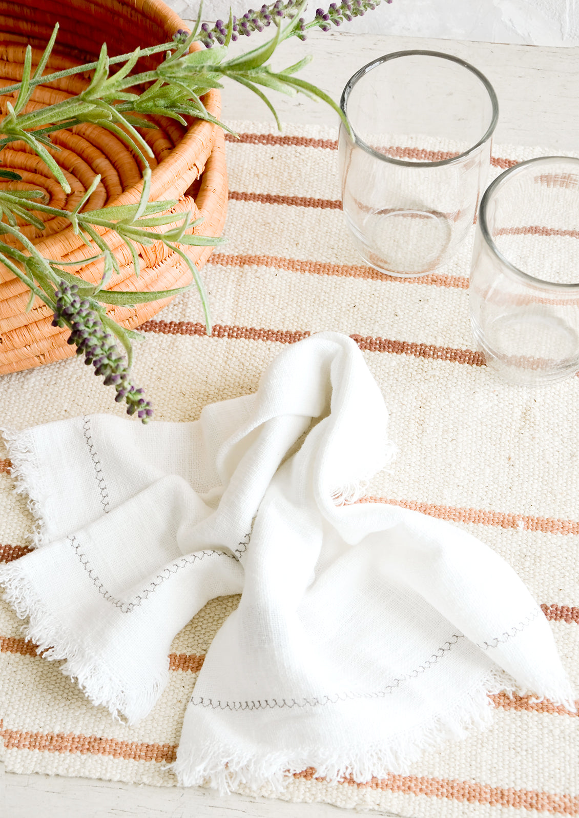 Serene table setting with neutral and white table linens and glass cups