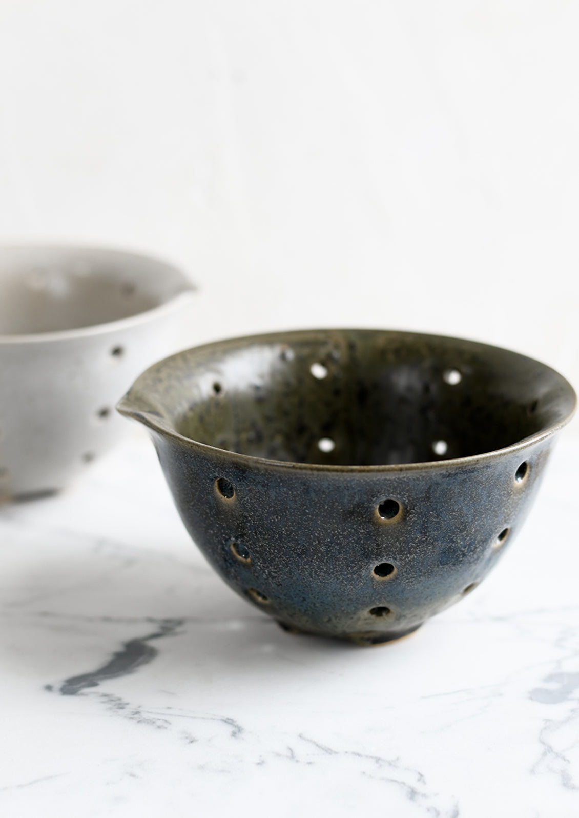 Stoneware ceramic colanders.
