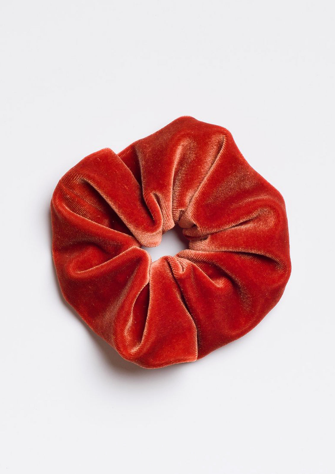 A velvet scrunchie in brick.