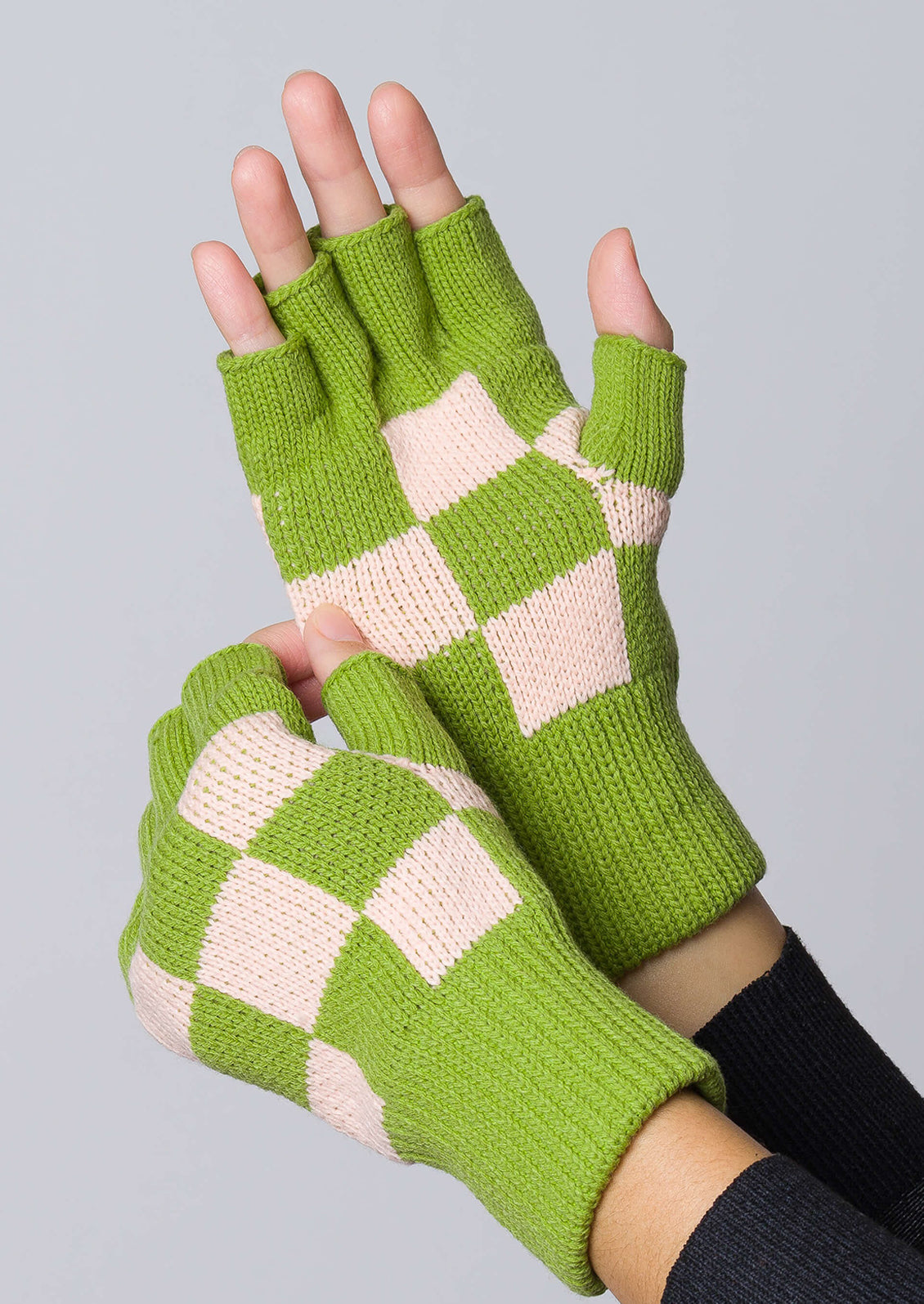 A pair of knit fingerless gloves in kiwi and blush checker.