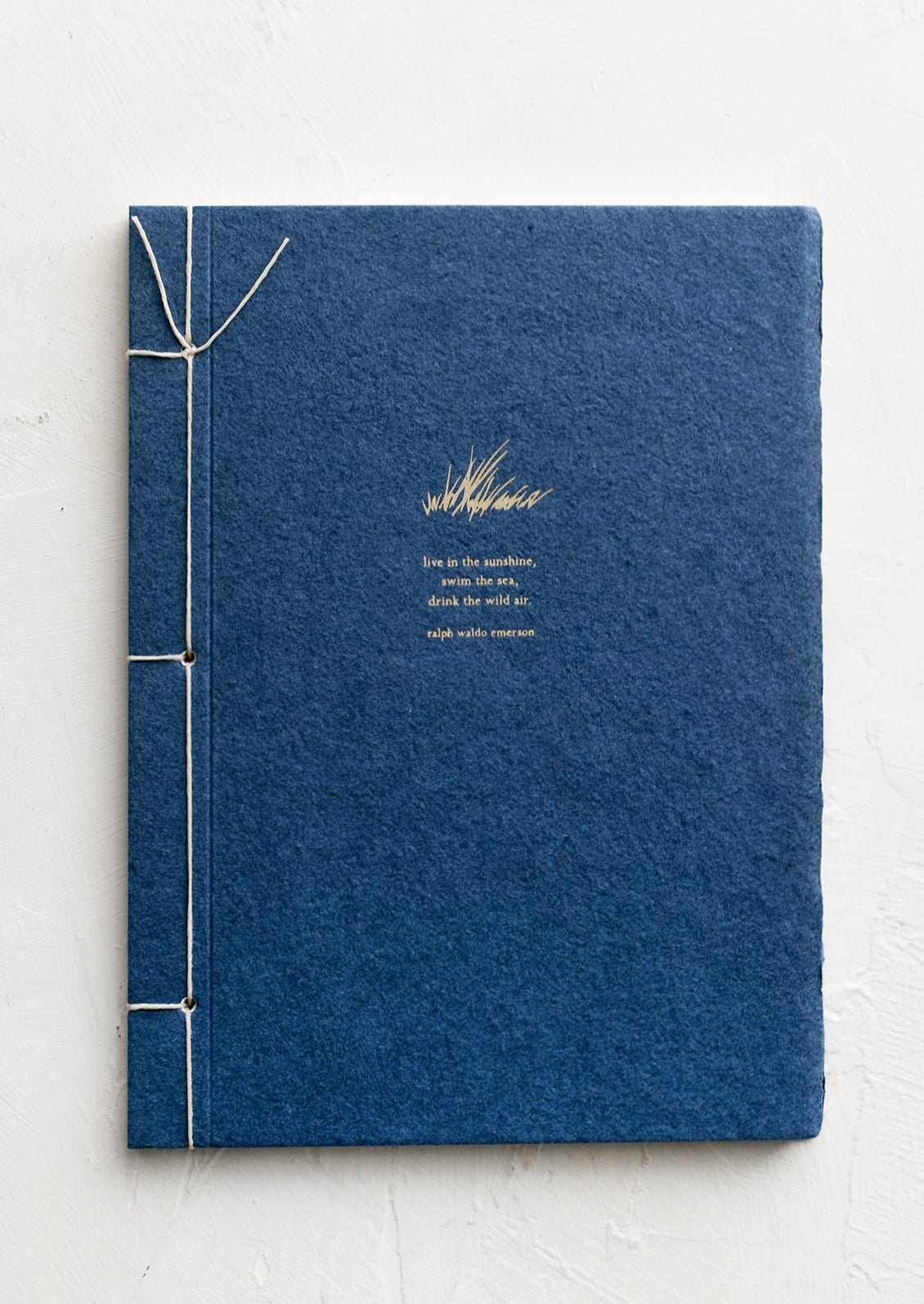 A journal with blue cover with Ralph Waldo Emerson quote.