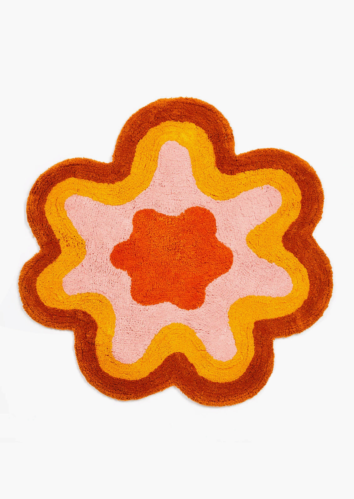 A wavy edge flower shaped bath mat in rust and orange.