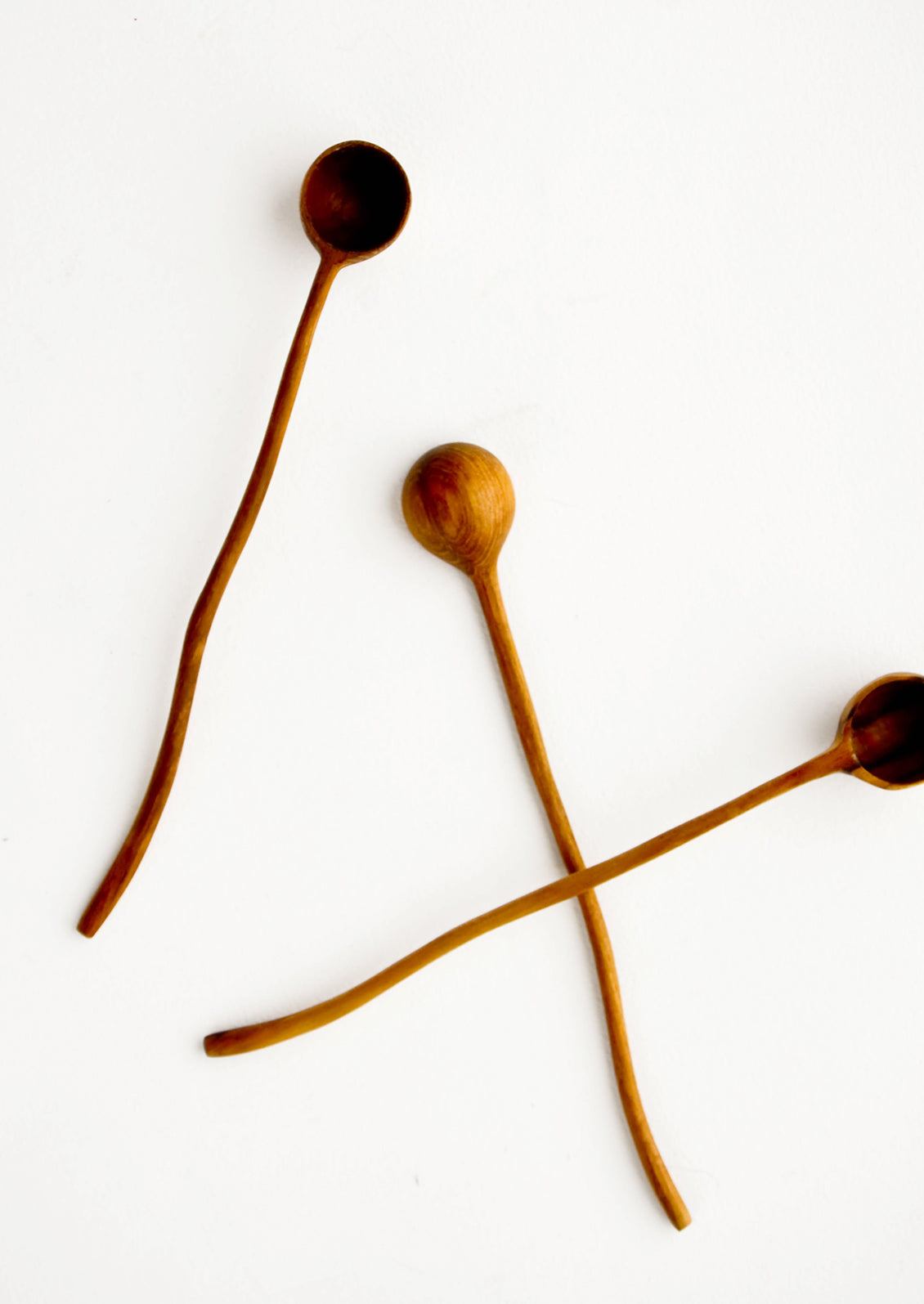 Wooden spoons with long, wavy handles and scoop-like basin