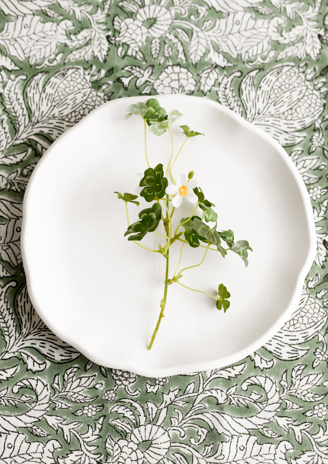 A round white concrete tray with ruffled, wavy edges.