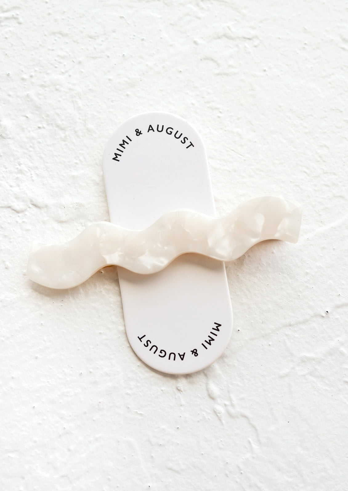 White pearl hair clip with wavy squiggle shape.