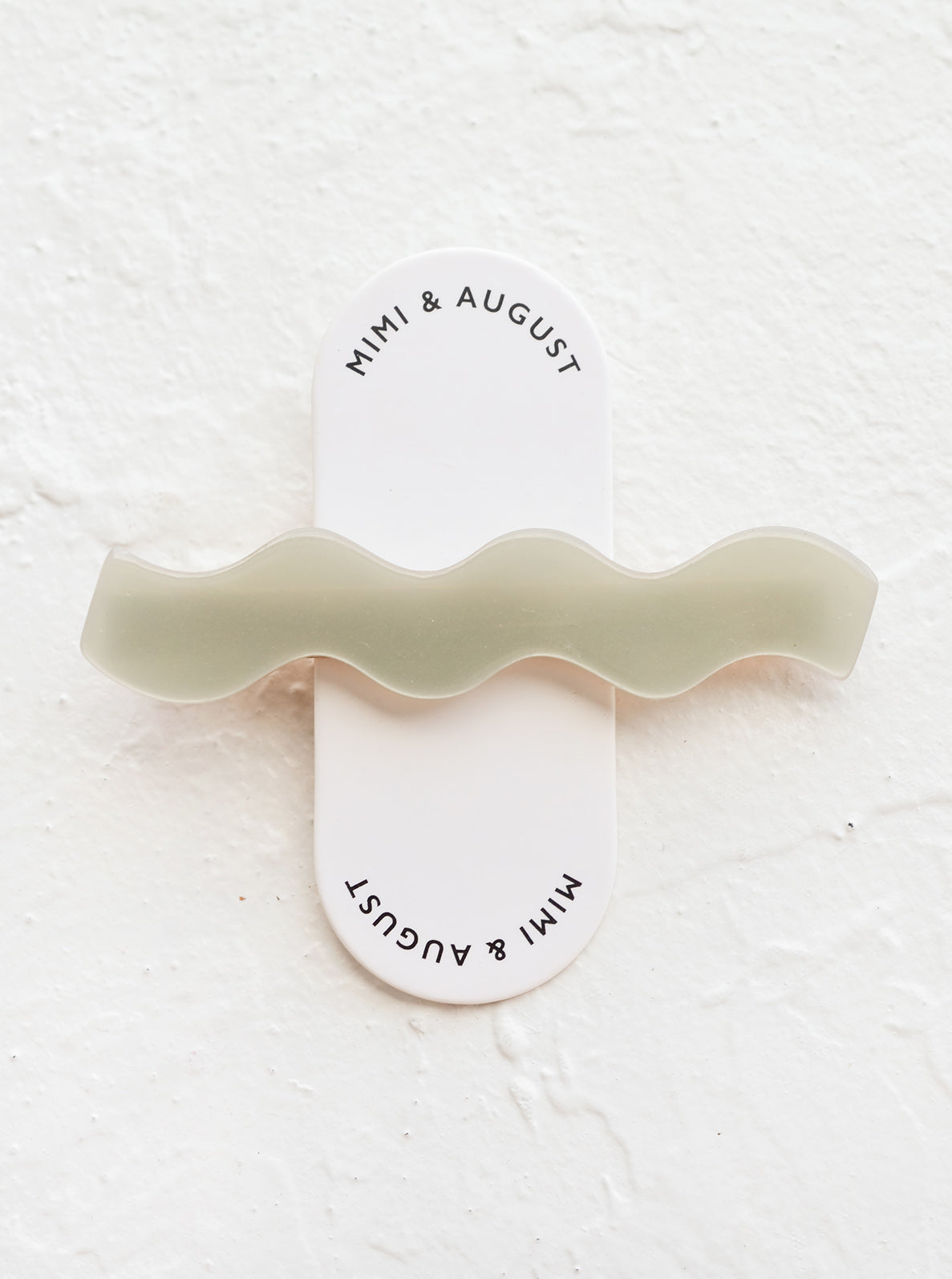 Sage green hair clip with wavy squiggle shape.